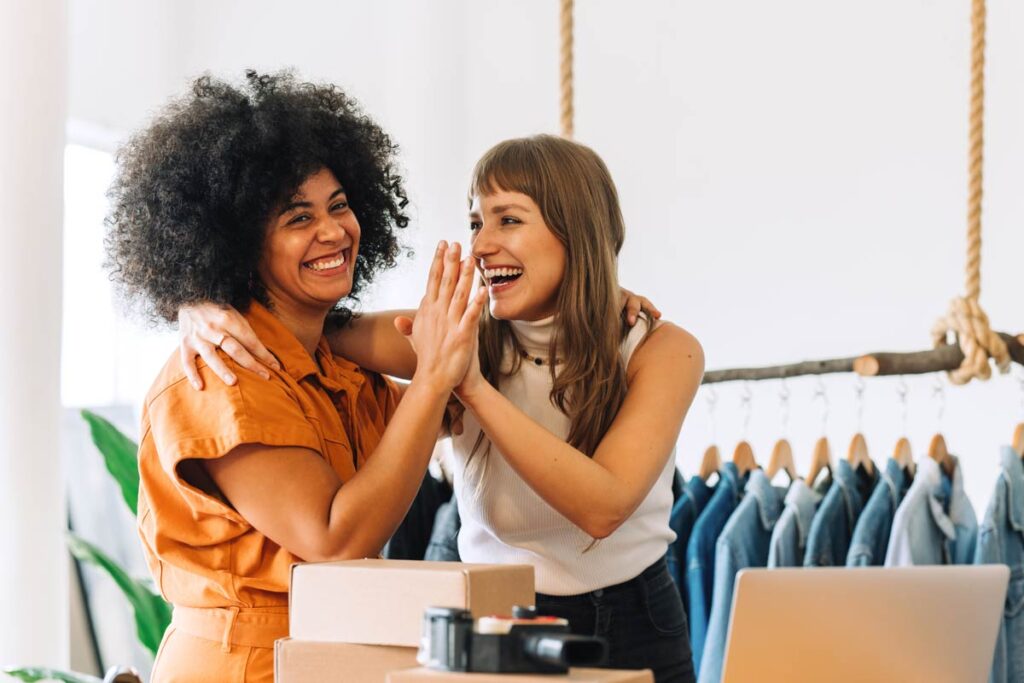 two female clothing designers celebrating business success
