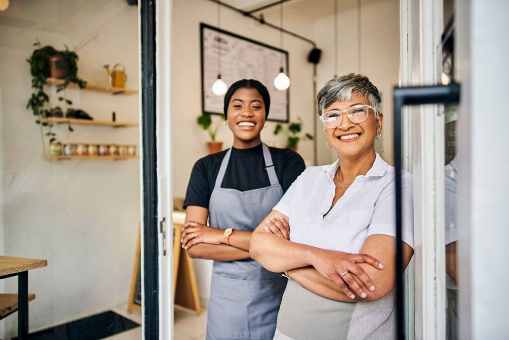 two female shop owners smiling in doorway