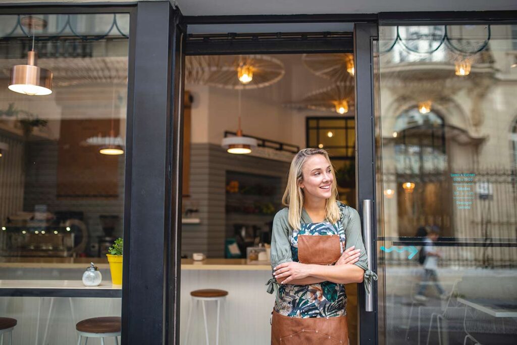 female cafe owner smiling in front of her store